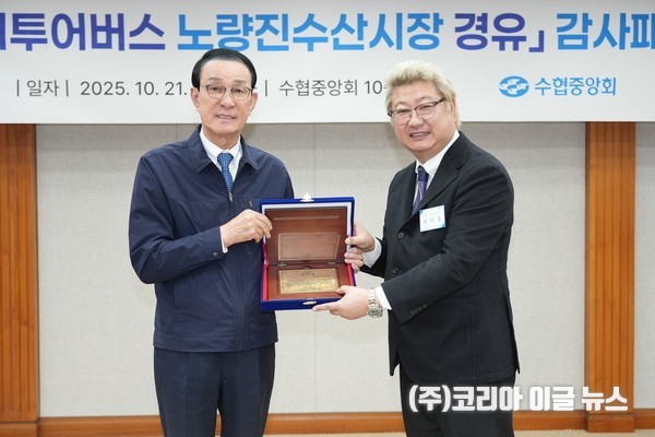 노동진 수협중앙회장이 서울시티투어버스 노선에 노량진수산시장을 유치해 낸 공로로 시장 상인회로부터 감사패를 수여받고 기념사진을 찍고 있다.  (사진/제공=수협중앙회)