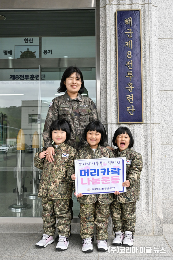해군 제8전투훈련단 소속 이은주 상사와 세쌍둥이 딸(왼쪽부터 장유진(둘째), 장은진(첫째), 장소진(셋째) 양, 5세)들이 지난달 26일 8전단 본부 앞에서 소아암 아동 돕기를 위한 머리카락 기부를 앞두고 기념사진을 촬영하고 있다.   (사진=해군)